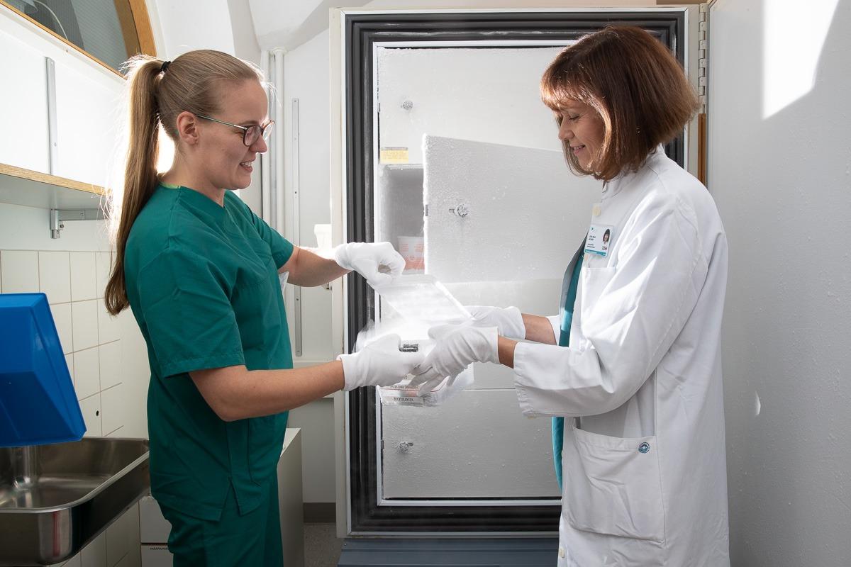 Maili Paaso ja Leena-Maija Aaltonen tutkimassa klinikalla pakastettuja, biopankkiin siirrettäviä näytteitä.